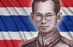 retrato do rei bhumibol adulyadej da conta de dinheiro de 50 baht tailândia perto do fundo da bandeira da tailândia foto
