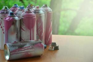 muitas latas de spray usadas de close-up de tinta. latas sujas e manchadas para desenhar grafite. o conceito de um desenho de tinta arrebatador e descuidado. imagem de arte criativa foto