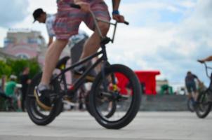 imagem desfocada de muitas pessoas com bicicletas bmx. encontro de fãs de esportes radicais foto