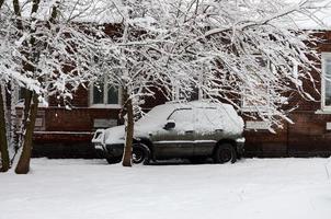 foto de um carro coberto por uma espessa camada de neve. consequências da forte nevasca