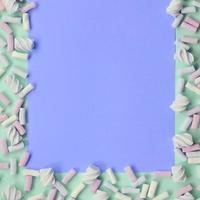marshmallow colorido disposto em fundo de papel verde e lilás foto