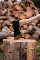 pronto para cortar madeira. close-up do log de corte de machado enquanto outros logs em segundo plano foto