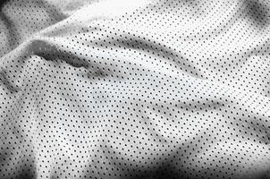 fundo de textura de tecido de roupas esportivas brancas. vista superior da superfície têxtil de pano branco. camisa de basquete brilhante. espaço de texto foto