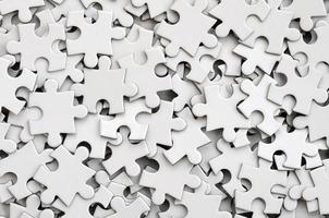 close-up de uma pilha de elementos incompletos de um quebra-cabeça branco. um grande número de peças retangulares de um grande mosaico branco foto
