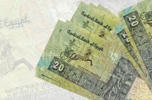 20 notas de libras egípcias encontram-se na pilha no fundo da grande nota semitransparente. apresentação abstrata da moeda nacional foto