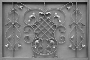 a textura do portão de metal prateado com um belo padrão floral de metal forjado foto