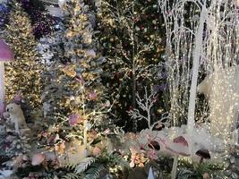 decorações de ano novo para o centro comercial. árvores de natal artificiais com iluminação. em um monte de neve ursos brancos, se escondendo da mãe-ursa. animais artificiais comemoram o ano novo foto