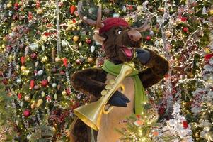 decoração de natal para um centro comercial. no centro está um veado tocando saxofone. veado tocando músicas de natal. ramos de abeto são decorados com miçangas e bolas coloridas foto