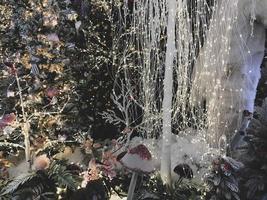 decorações de ano novo para o centro comercial. árvores de natal artificiais cobertas de neve. ursos polares em um monte de neve. ao lado deles estão altos cogumelos multicoloridos e iluminação foto