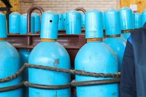 grandes cilindros de gás azul de metal de ferro com oxigênio, ar, hélio sob pressão interna excessiva para armazenar gases comprimidos, liquefeitos e dissolvidos sob pressão foto