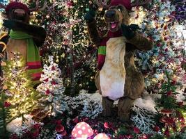 véspera de Natal. há cervos de brinquedo altos no shopping. renas tocam música de ano novo no saxofone e cantam músicas. entretenimento para os visitantes do centro comercial. veado em lenços fofos foto