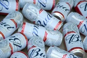 kharkov, ucrânia - 9 de dezembro de 2020, muitas latas de cerveja de álcool budweiser lager estão na superfície da camuflagem. budweiser é a marca da anheuser-busch inbev mais popular da américa foto