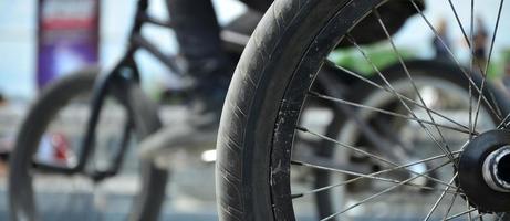 uma roda de bicicleta bmx no contexto de uma rua turva com ciclistas. conceito de esportes radicais foto