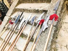 as antigas armas frias medievais, machados, alabardas, facas, espadas com cabos de madeira lambem os degraus de pedra do castelo foto