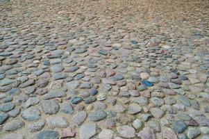 a textura da estrada de pedra, pavimento, paredes de grandes pedras fortes redondas medievais antigas cinzentas, paralelepípedos. o fundo foto