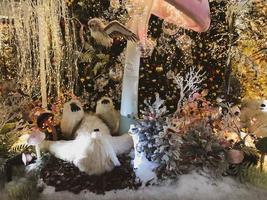 decorações de Natal. um urso polar de brinquedo está sob um cogumelo colorido e move suas patas. guirlandas coloridas, decoração festiva para um shopping center foto