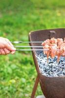 mãos de homem prepara carne de churrasco foto