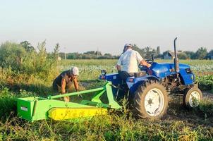 kherson oblast, ucrânia, 14 de setembro de 2020, trabalhadores agrícolas em um trator cavam batatas. agricultura e agricultura. colhendo batatas na plantação, separando e embalando em sacos de malha. foto