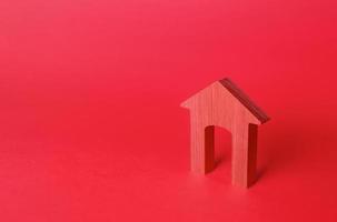 estatueta de casa de arco vermelho. habitação a preços acessíveis. aluguel de imóveis. reparação e renovação, modernização. minimalismo. fundo de login vermelho. entrada do conceito. serviços de corretor de imóveis. foto