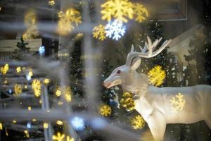 estátua de veado branco em bokeh de primeiro plano de floco de neve. foto