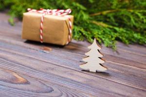 pequena árvore de natal de madeira branca decorativa e presente com conceito de ano novo de fita vermelha, presente de papel kraft foto