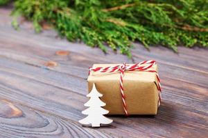 composição de natal. presentes de natal com árvore de natal decorativa e galhos de thuja em fundo branco de madeira foto