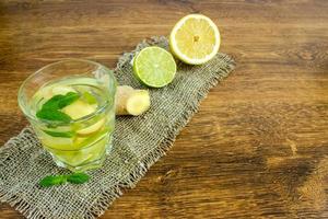 refrigerante de gengibre orgânico em um copo com limão e limão foto