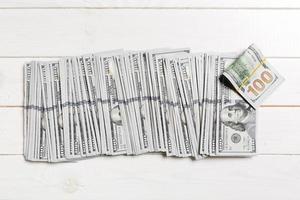 vista superior de mentir notas de 100 dólares em uma linha sobre fundo de madeira. close-up do conceito de economia de dinheiro foto
