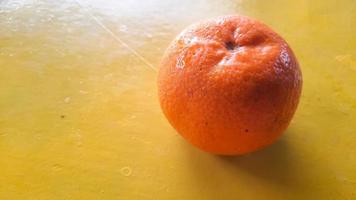 alto ângulo, fruta laranja fresca em um fundo amarelo foto