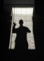 sombra de uma pessoa acenando em uma moldura de porta foto