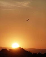 avião subindo para o céu durante o pôr do sol em florença, itália foto