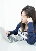 jovem estudante sentada na sala de estar e aprendendo online foto
