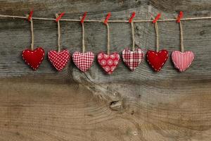 corações de dia dos namorados amor guingão pendurados em uma textura de madeira foto
