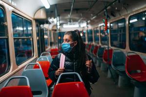 jovem com máscara viajando no transporte público. foto