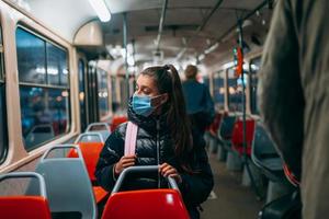 jovem com máscara viajando no transporte público. foto