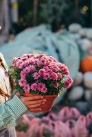 mulher segurando flor decorativa em vaso de flores no mercado. foto