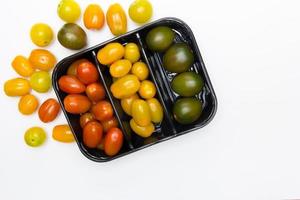 tomates cereja dentro e ao redor de uma caixa preta foto