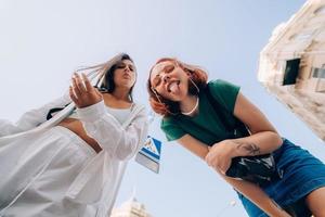 dois amigos olha para baixo ao ar livre na rua para a câmera foto