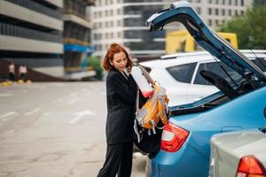 uma mulher coloca coisas no carro foto