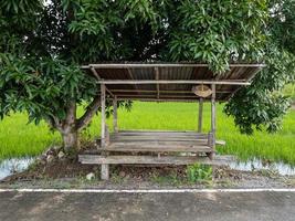 o antigo abrigo de madeira para agricultores ao lado da estrada local perto do arrozal. foto