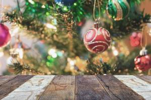 tampo de mesa de madeira vazio com árvore de natal desfocada com fundo claro bokeh foto