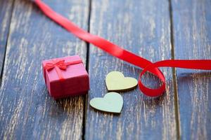 dois corações moldam brinquedos e presentes em fundo de madeira. foto