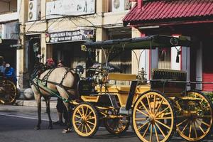 yogyakarta, indonésia, em 23 de outubro de 2022. andong ou carruagem puxada por cavalos com seu cocheiro estacionado em jalan malioboro, esperando passageiros. foto