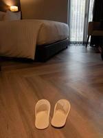 novos chinelos brancos no chão do hotel foto