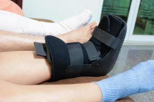 suporte de bota na perna da mulher para apoiar o tornozelo lesionado foto