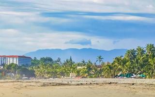 palmeiras guarda-sóis espreguiçadeiras balneário zicatela puerto escondido méxico. foto