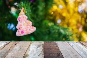 tampo de mesa de madeira vazio com árvore de natal desfocada com fundo claro bokeh foto