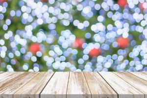 tampo de mesa de madeira vazio com árvore de natal desfocada com fundo claro bokeh foto