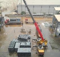 um guindaste levanta uma caixa de metal para a construção de uma fábrica foto