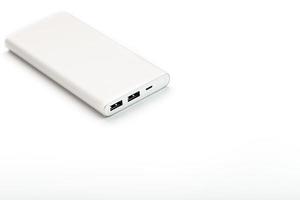 banco de potência para carregar seu smartphone em um fundo branco. bateria externa universal para gadgets espaço livre e composição minimalista. foto